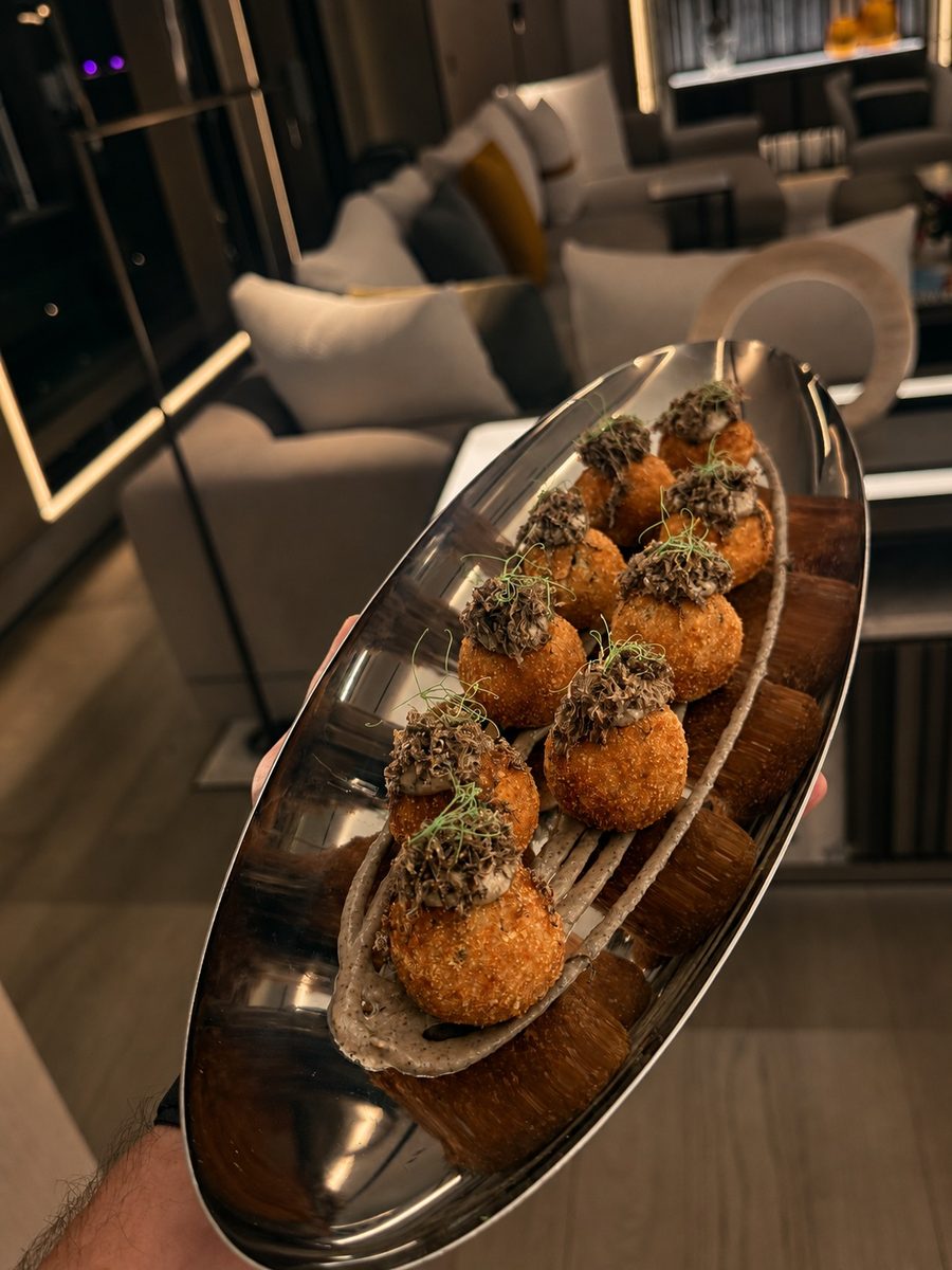 Golden croquettes with dipping sauce and herbs