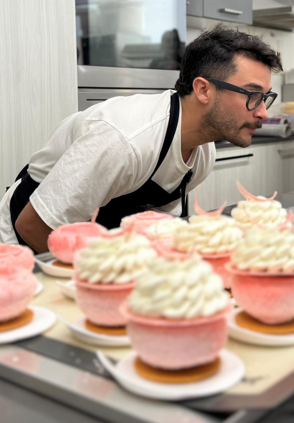 Chef Luke Patton checking a tray of plated desserts